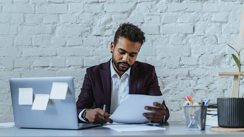 Working as an unpaid intern not only allows you to avoid accruing OPT unemployment days but could also open doors to a paid position within the company. a male intern working on a desk with a laptop