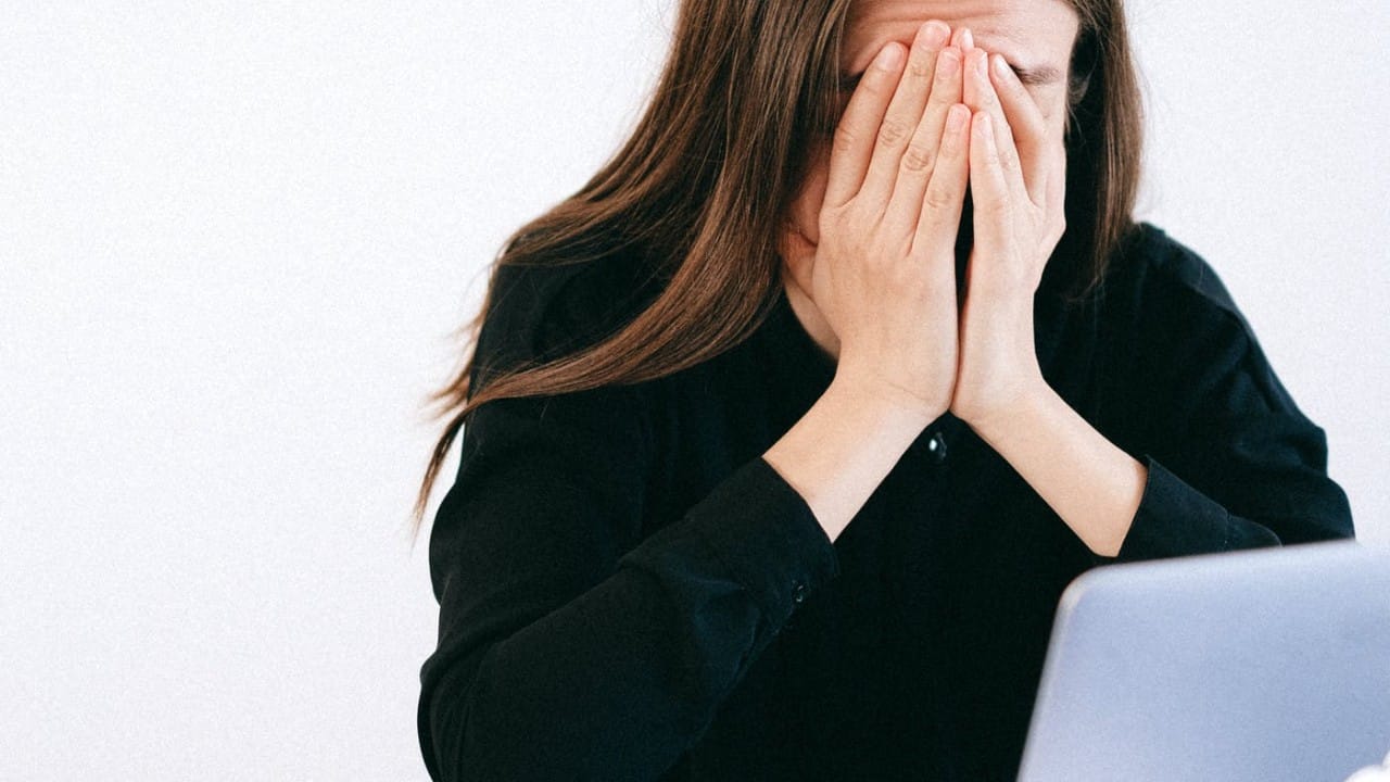 A woman with her face in her palm